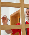 Man using Easy Touch Up Paint Pens Refillable Wall Repair Kit on wooden door frame for touch-ups and repairs.