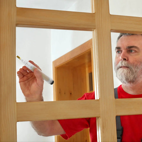 Man using Easy Touch Up Paint Pens Refillable Wall Repair Kit on wooden door frame for touch-ups and repairs.