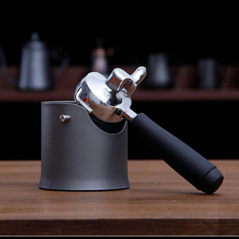 Heavy Duty Shock Absorbent Coffee Knock Box For Espresso Machines with a metal portafilter resting in the black base.