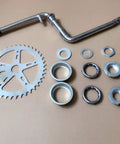 Wide 2 Inch Cup Pedal Crank Kit One Piece Crank For 2 Stroke Gas Motorized Bicycle 48cc 66cc 80cc 44T Sprocket Fits Normal 26 Inch Frames Durable Aluminum Alloy Construction Plug And Play Easy Install And Precise Alignment. One-piece crank kit with 44T sprocket and bearings laid out on a flat surface