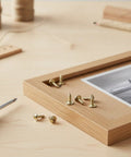 Gold Self-Tapping Picture Frame Screws With Integrated Washers For DIY Crafts on a wooden frame with screwdriver.