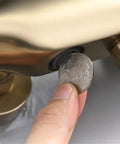 UMJIGF 10 Inch Shower System Brushed Gold Shower Faucet Set with a hand inserting a coin into the faucet for maintenance.