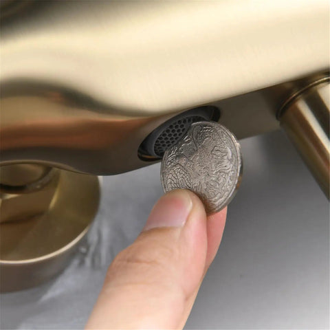 UMJIGF 10 Inch Shower System Brushed Gold Shower Faucet Set with a hand inserting a coin into the faucet for maintenance.