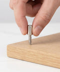 Hand holding screw from Self-Tapping Cabinet Screws Kit With 150 Non-Slip Sleeve Shelf Pins And 150 Sleeves Beefy Heavy-Duty Bookcase Pegs