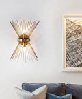 Mid Century Style Wall Sconce With Antique Brass Brush Finish And Starburst Shade on a white wall above a sofa