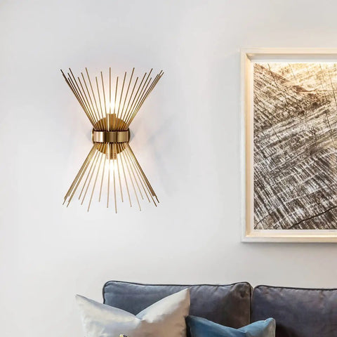Mid Century Style Wall Sconce With Antique Brass Brush Finish And Starburst Shade on a white wall above a sofa