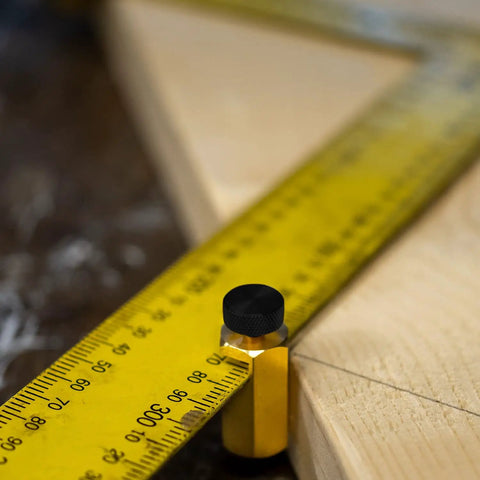 Beefy Brass Stair Gauge Set For Framing And Carpentry Squares showing brass body with large knobs on yellow ruler for precise cuts
