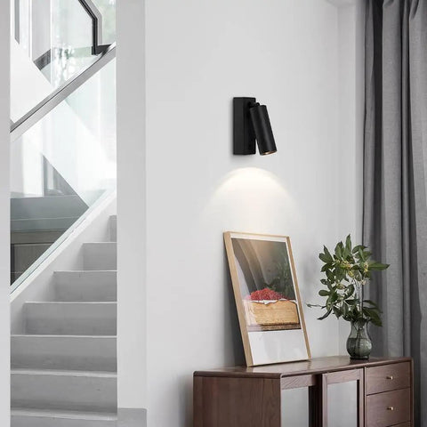JGSYD Bedside Reading Lamp, Adjustable Metal Wall Light, Black Wall Sconce, mounted on white wall above wood cabinet.