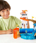 Child playing with Hot Wheels Color Shifters Sharkport Showdown Track Set with 1 64 Scale Car, Shark-themed ramp and splash pool.