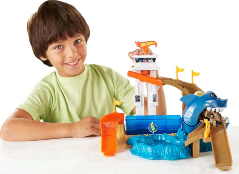 Child playing with Hot Wheels Color Shifters Sharkport Showdown Track Set with 1 64 Scale Car, Shark-themed ramp and splash pool.