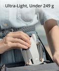 Person placing Mini 3 Drone With RC Remote Bundle Portable 4K Quadcopter Kit into waistband pouch showcasing ultra-light design.
