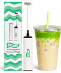 Electric Milk Frother And Matcha Whisk Handheld All-In-One Blender Stainless Steel USB Rechargeable High-Speed Immersion Mixer next to iced drink