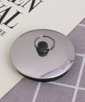 2pcs Rubber Bathtub Drain Stopper for Kitchen and Laundry Use, round rubber seal with metal ring on gray fabric.