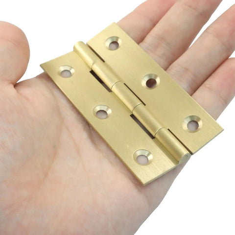 Built Rock Solid 3 Inch Mini Brass Hinges in hand, showcasing solid construction for cabinet upgrades.