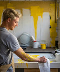 Man cleaning paint spills with 350 Count White Heavy-Duty Shop Towels, Ultra Absorbent Industrial Wipers in kitchen