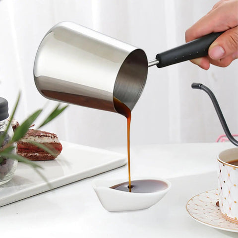Person pouring coffee from Turkish Coffee Pot And Milk Frothing Jug 21oz 600ml Stainless Steel Toroid Pitcher with long handle.