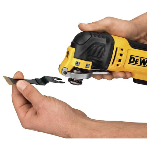 Hands holding an Oscillating Tool With 3 Amp Corded Motor, Quick Change Attachments visible, demonstrating blade attachment.