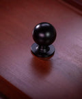 Matte Black Cabinet Knob with Large Ball Design on Wood Surface for Kitchen Cabinets and Dressers