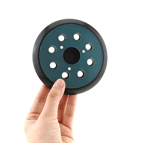 5 Inch 8-Hole Replaceable Oscillating Sanding Pad For Metal Finishing, held by hand, showing dust extraction holes