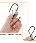 Hand holding black S Hook from Four Pack Large Grid Wall Baskets With S Hooks For Garage Or Display Shelves Heavy Duty Black Metal Gridwall Organizer Bins Set Modular Storage Caddies For Photo Displays And Panel Shelving