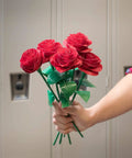 Hand holding a bouquet of roses crafted from duct tape in front of lockers.