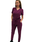 Women's Slim High Waisted Jogger Scrub Pants Yoga Style Nursing Uniforms Wine Color worn by model, showcasing tapered design and pockets.