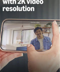 Person on phone screen demonstrating Mini 2K Plus Plug In Indoor Security Camera For Home And Pets with 2K Video and 4x zoom.