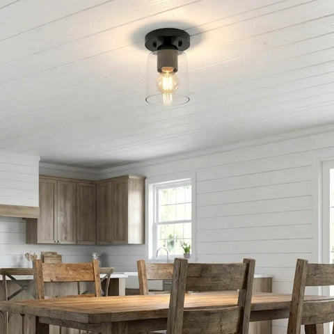 Industrial Semi Flush Mount Ceiling Light With Cylinder Glass Shade And E26 Base installed in a kitchen with black matte finish.