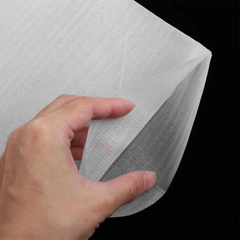 Close-up of a hand holding a white EPE foam pouch from the White EPE Foam Pouches 200 Pack For Packing And Shipping Cushioning And Shock Absorption