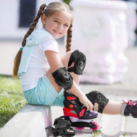 Child wearing Kids Protective Gear Set Knee Elbow And Wrist Guards For Roller Skating Skateboarding BMX Cycling Inline Skating And Scooter Riding Size Medium Black Durable 3 Piece Safety Gear For Beginners, sitting with roller skates outdoors.