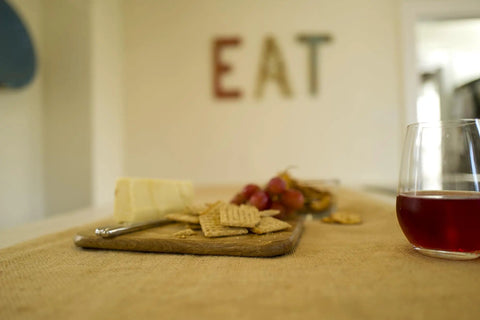 Heavy Duty Burlap Garden Fabric 12 Oz Odorless Food Grade used as a table covering under cheese, crackers, and a glass of wine.