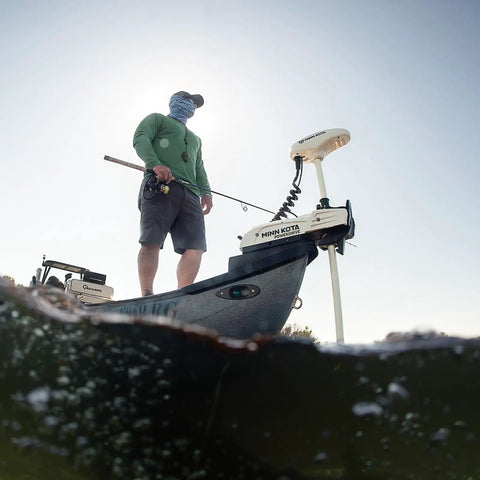 Man on boat using Bow Mount Electric Trolling Motor Featuring GPS Spot Lock And Handheld Micro Remote.