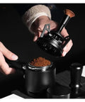 Smooth Operator Espresso Rotary WDT Tool And Coffee Stirrer With Built In Dosing Funnel Stand For Even Powder Distribution and Knockout Barista Shots At 54mm in use with coffee grounds.