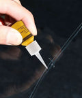Applying Glass Nano Repair Fluid Windshield Kit For Small Chips And Cracks onto a windshield crack using a yellow resin tube
