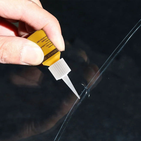 Applying Glass Nano Repair Fluid Windshield Kit For Small Chips And Cracks onto a windshield crack using a yellow resin tube