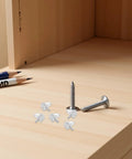 Plastic Shelf Pegs Set 150 Pack 3mm Diameter With 0.11 Inch Hole Locking Design on wood surface with screws and pencils