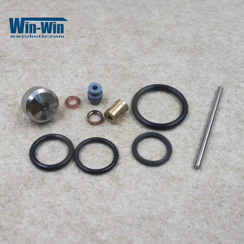 Front view of waterjet maintenance kit parts: O-rings, brass valve fitting, blue spacer, copper washers, stainless rod.