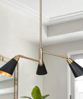 Three Light Modern Black And Gold Chandelier With Copper Brass Finish in a bright room setting, slanted shades visible