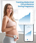 Pregnant woman using Smart Body Measuring Tape With Bluetooth App to track abdominal circumference and progress on phone app.