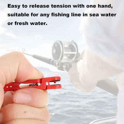 Front view: YUNNLEZT downrigger release clip, red, held by hand with fishing rod over the ocean