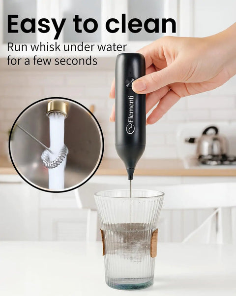 Using Rechargeable Milk Frother Wand USB-C Handheld Drink Mixer For Home Barista Vibes over glass for easy cleaning demonstration.