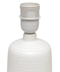 Close-up of textured linear ceramic table lamp in off-white without shade, pottery style, cozy vibe.