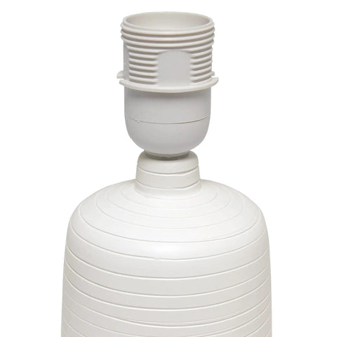 Close-up of textured linear ceramic table lamp in off-white without shade, pottery style, cozy vibe.