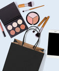Black Kraft Paper Gift Bags With Handles 5.25 X 3.75 X 8 Inches next to makeup and smartphone