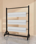 Heavy Duty Vinyl Roll Storage Rack With Wheels displaying four large rolls of fabric on a sturdy steel frame, ideal for organizing materials.