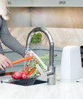 Woman washing vegetables with Replacement Filter Cartridge For Countertop Water Filtration System That Delivers Crisp Tasting Water