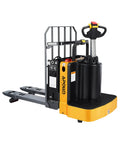 Built Tough Full Electric Pallet Truck Powers Through 5500 Lbs On The Regular With Side Standing Platform view of yellow pallet truck with forks and controls.