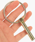 Hand holding a zinc plated lynch pin from 12 Piece Zinc Plated Beefed Up Heavy Duty Lynch Pins With Ring Linch Pin Assortment Kit