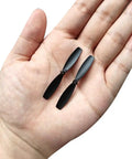 55mm RC Propellers CW CCW 2 Vane Main Rotors Black 2 Pairs For Drones, 1mm Shaft, 5mm Thick in a hand