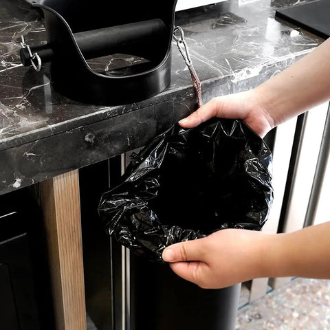 Person holding espresso knock box garbage bag, 13x35 inches, for floor standing bins, heavy duty, eco-friendly, commercial use.
